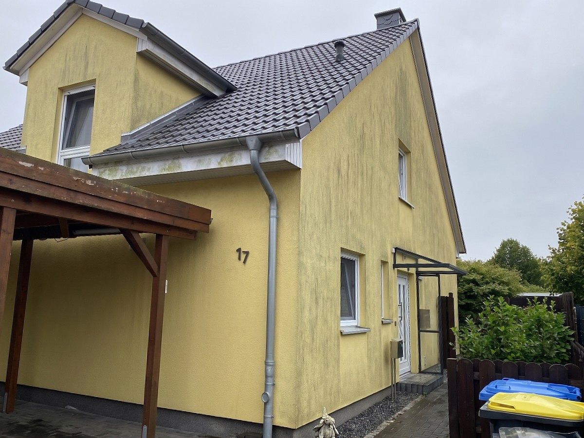Einfamilienhaus, Putzfassade mit Grauschleier, vor der Reinigung.
