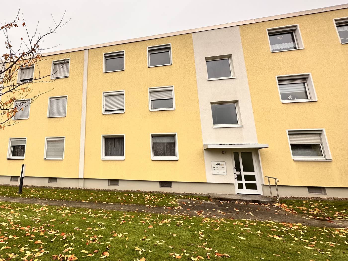 Dasselbe Mehrfamilienhaus nach der Reinigung, der gelbe Putz wieder klar.